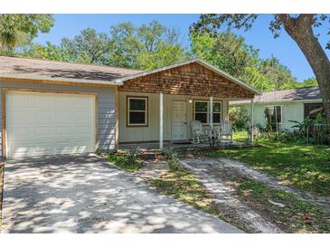 Charming home featuring a cozy front porch with rocking chairs and a well-maintained front yard at 186 Grand Ave, Brooksville, FL 34604