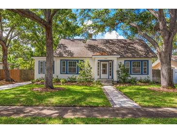 Charming home featuring a well-manicured lawn, beautiful trees, and classic architecture with eye-catching blue shutters at 1905 Mckinley St, Clearwater, FL 33765