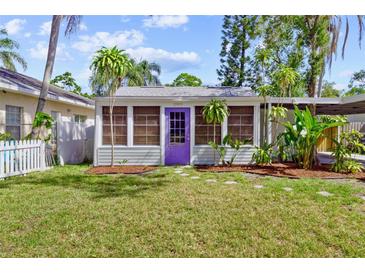 Charming home featuring a well-manicured lawn and a lovely purple front door at 2909 60Th N Ave, St Petersburg, FL 33714