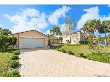Charming single-story home with a brick driveway and a well-manicured lawn surrounded by lovely palm trees at 4120 Marine Pkwy, New Port Richey, FL 34652