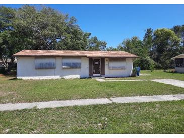 A single-story home showing boarded up windows and front yard at 9355 Pinero St, Spring Hill, FL 34608