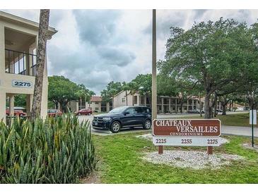 Condominium complex featuring well-manicured landscaping and signage for 'Chateaux Versailles Condominiums' at 2275 62Nd N Ave # 5202, St Petersburg, FL 33702