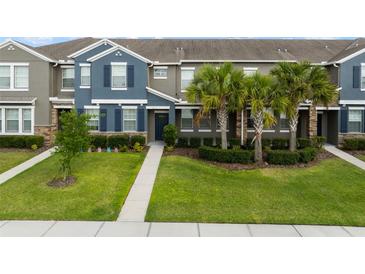Charming townhouse featuring a manicured lawn, tasteful landscaping, and classic shutters, inviting curb appeal at 6337 Shore Vista Pl, Apollo Beach, FL 33572