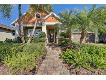 Beautiful home featuring mature landscaping, a brick paved walkway, and a welcoming front entrance at 7209 Meeting House Ln, Apollo Beach, FL 33572