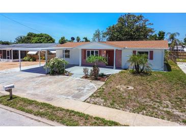 Charming single-story home with brick accents, a well-maintained lawn, and a convenient covered carport at 1153 Honor Dr, Holiday, FL 34690