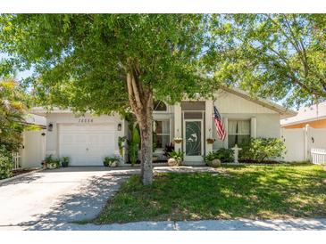 Charming single Gathering home with manicured lawn, flowering trees, and front-facing two car garage at 15856 49Th N St, Clearwater, FL 33762