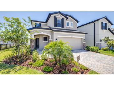Charming two-story home features a two-car garage, manicured lawn, and lovely landscaping at 31966 Asbury Ave, Wesley Chapel, FL 33545