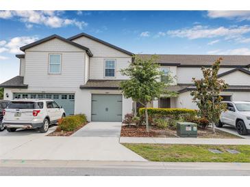 Charming townhome showcasing a well-manicured lawn and a two-car garage, nestled in a desirable neighborhood at 5429 Companion Ln, Tampa, FL 33619