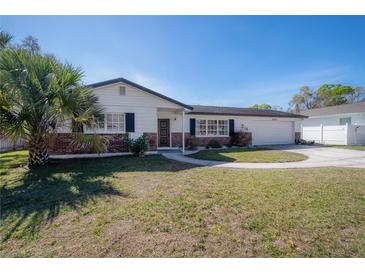 Charming single Gathering home with a lush green lawn and brick accents at 6765 Ralston Beach Cir, Tampa, FL 33614