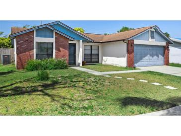Charming single-story home features a brick facade and well-maintained front lawn with stepping stones at 747 Stillview Cir, Brandon, FL 33510