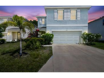 Charming two-story home with a two-car garage, lush landscaping, and a beautiful sunset backdrop at 7591 Cypress Walk Dr, New Port Richey, FL 34655