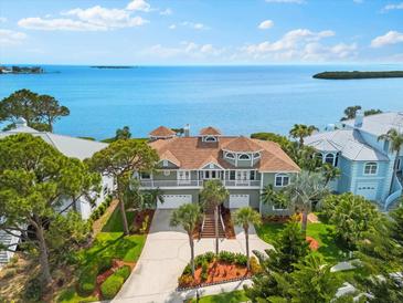 Beautiful waterfront home with lush landscaping, a private balcony, and a three-car garage at 2081 Pointe Alexis Dr, Tarpon Springs, FL 34689