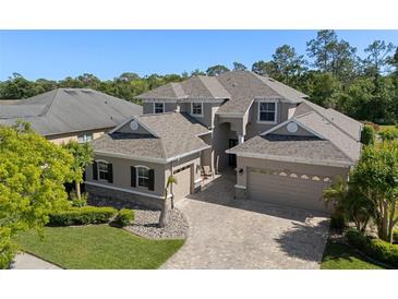 Beautiful two-story home showcasing a three-car garage and lush landscaping at 27318 Sora Blvd, Wesley Chapel, FL 33544