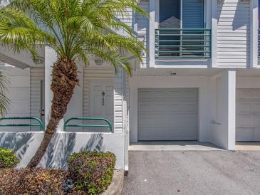 Charming condo exterior featuring a private garage, well-maintained landscaping, and a welcoming front door at 320 Island Way # 606, Clearwater Beach, FL 33767