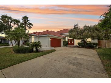 Beautiful single Gathering home with a red tile roof, red garage door, and well manicured yard at 915 Live Oak Ne Ter, St Petersburg, FL 33703