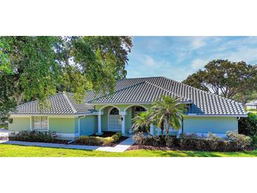 Charming single-story home featuring a beautiful tiled roof and well-manicured front yard at 9159 Highland Ridge Way, Tampa, FL 33647
