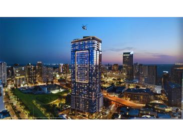 Stunning exterior shot of a modern high-rise with a helicopter on the roof at night at 1101 E Jackson St # 2102, Tampa, FL 33602