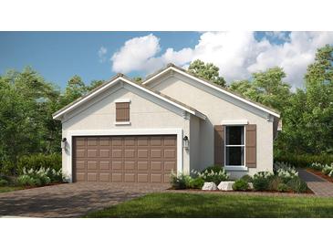 Charming single-story home featuring a two-car garage, manicured lawn, and neutral color palette at 29516 Zupetta Ln, Wesley Chapel, FL 33545