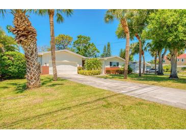 Charming single-story home with a well-manicured lawn and mature palm trees at 775 S Bayshore Blvd, Safety Harbor, FL 34695