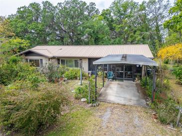 Charming single-story home with a metal roof, covered carport, and beautiful landscaping at 117 Myrtle Ln, Plant City, FL 33565