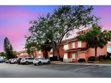 Condo exterior at dusk with parking, colorful buildings, and mature trees at 3675 41St S Way # K, St Petersburg, FL 33711