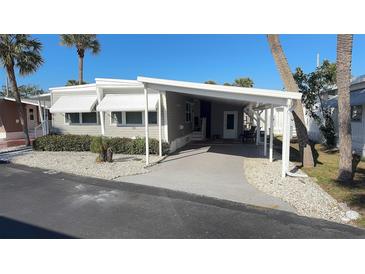 Charming single-story home with awning, covered porch and driveway, perfect for easy living and outdoor enjoyment at 4851 W Gandy Blvd # B12L28, Tampa, FL 33611