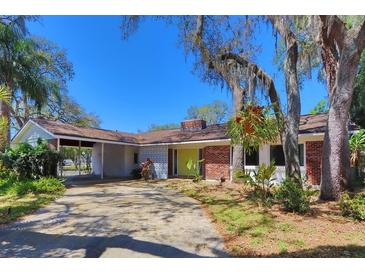 Charming single-story brick home featuring a welcoming carport and mature, verdant landscaping at 7802 N 53Rd St, Tampa, FL 33617