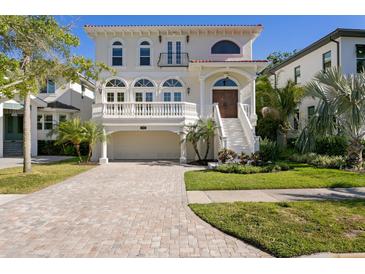 Stunning two-story home with a brick driveway, manicured lawn, and grand staircase entry at 102 Adriatic Ave, Tampa, FL 33606