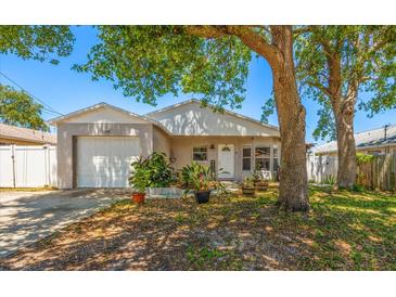 Charming single-story home featuring a well-manicured lawn, mature trees, and an attached one-car garage at 1108 16Th Nw Ave, Clearwater, FL 33756