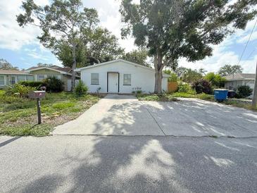 Charming single-story home with a concrete driveway and well-maintained front yard landscaping at 112 N Betty Ln, Clearwater, FL 33755