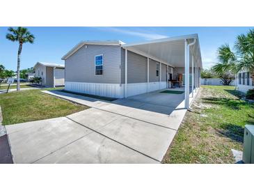 Charming home featuring gray siding, white trim and a covered carport for convenient parking and protection from the elements at 262 S Port Royal Ln, Apollo Beach, FL 33572