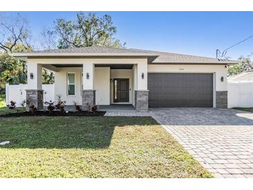 Beautiful single Gathering home featuring a two car garage, stone accents, and a covered front porch at 3326 W Heiter St, Tampa, FL 33607