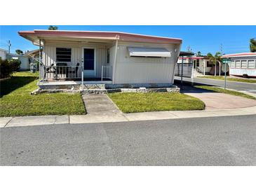 Charming single-story home with a cozy front porch and well-maintained lawn at 34461 Cactus Dr, Pinellas Park, FL 33781