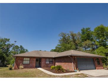 Charming single-story brick home featuring a well-maintained yard and attached garage at 35109 Excalibur, Webster, FL 33597