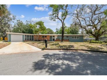Charming single-story home with a brick accent, well-manicured lawn and attached garage at 422 Dunedin Cir, Temple Terrace, FL 33617