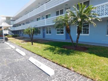Light blue building with covered parking and palm trees in a well-maintained visitor parking area at 4715 Bay Ne St # 119, St Petersburg, FL 33703
