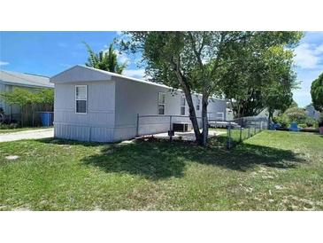 View of a manufactured home, showcasing its siding and surrounding fenced yard at 5830 Portsmouth Dr, Tampa, FL 33615