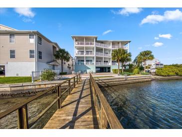 Waterfront condo featuring a private dock and multiple balconies with stunning water views on a clear, sunny day at 19817 Gulf Blvd # 602, Indian Shores, FL 33785