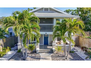 Charming two-story home features a blue door, an upstairs balcony, and tropical landscaping at 2635 13Th N Ave, St Petersburg, FL 33713