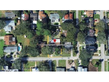 Aerial view of the property surrounded by mature trees in a residential neighborhood at 312 N Manhattan Ave, Tampa, FL 33609