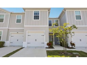 Light and bright townhome exterior with a one car garage and tidy landscaping at 3158 Victoria Inlet Dr, Holiday, FL 34691