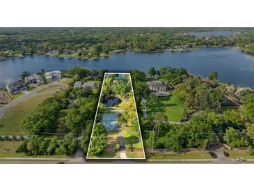 Sprawling waterfront property with a private pond, tennis court, and lush landscaping at 3407 W Busch Blvd, Tampa, FL 33618