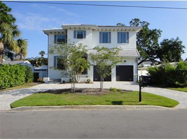 Inviting two-story home with a well-manicured lawn and a two-car garage at 5009 W Longfellow Ave, Tampa, FL 33629