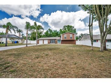 Charming two-story home with a spacious front yard, palm trees, and three-car garage at 613 Valley Hill Dr, Brandon, FL 33510