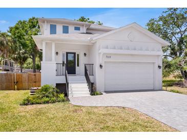 Beautiful two-story home with white stucco, black accents, two car garage and inviting curb appeal at 7113 S Kissimmee St, Tampa, FL 33616