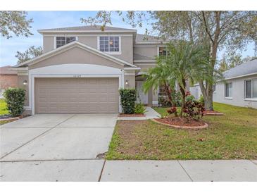 Charming two-story home boasts a well-manicured lawn, a two-car garage, and complemented by lush tropical landscaping at 10525 Lucaya Dr, Tampa, FL 33647