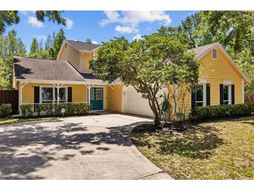 Charming yellow home with a well-maintained lawn and driveway at 305 Bryan Oak Ave, Brandon, FL 33511
