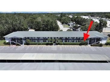 Spacious condo building featuring ample parking, lush landscaping, and convenient access to nearby amenities at 100 Glennes Ln # 108, Dunedin, FL 34698