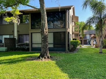 Condominium exterior featuring well-maintained lawn and patio seating at 12920 Wedgewood Way # A, Hudson, FL 34667