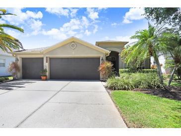 Charming home featuring a three-car garage, well-maintained landscaping, and a concrete driveway at 16118 Lytham Dr, Odessa, FL 33556